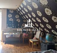 The interior of the cottage with floral wallpaper and a wooden decor floor.