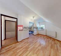 A room in a 5 or more bedroom apartment with a wooden decor floor and a window.