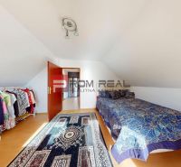 A bedroom with a bed, a clothes rack, and a floor with a wooden decor in a 5 or more room apartment.
