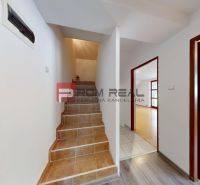 A hallway with wooden doors and a staircase in a 5 or more room apartment.