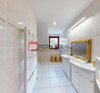 Bathroom with tiles, two sinks, and a mirror, in a family house.