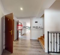 A hallway of a 2-room apartment with a wooden decor floor and a staircase.