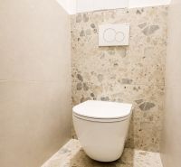 A toilet in a 3-room apartment with stone cladding and a fresh design.