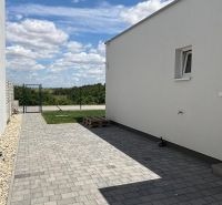 A family house in Boldog with paving, a white facade, and a closed courtyard.