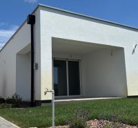 A family house in Boldog with a terrace and a landscaped garden, with a view of the blue sky.