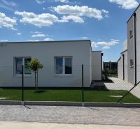 A family house in Boldog with a white facade, garden, and fence.
