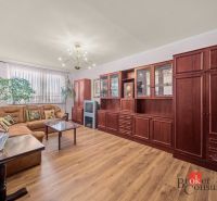 Living room with a sofa set, wooden decor flooring, large display cabinet, 3-room apartment.