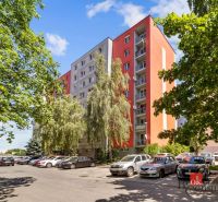 An apartment building on E. F. Scherer Street in Piešťany, surrounded by greenery and parked cars.