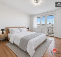 A bright bedroom with a bed and wood-decor flooring in a 3-room apartment.