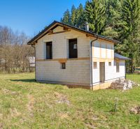 The exterior of a family house in Lazy pod Makytou surrounded by nature and a grassy area.
