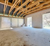 The interior of a family house with a wooden ceiling and large open spaces.