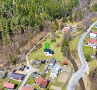 An aerial view of family houses in Lazy pod Makytou surrounded by forests and a road.