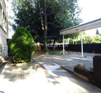 Outdoor terrace in commercial premises in Senica surrounded by trees and greenery.