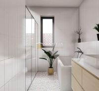 Bathroom in a family house with a bathtub, a plant, and patterned flooring.