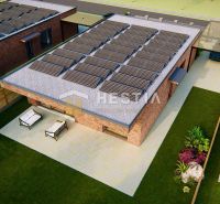 A family house in Hlboké with a terrace, lawn, and solar panels on the roof.