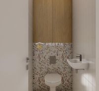 A toilet in a family house with a sink and terrazzo tiles.