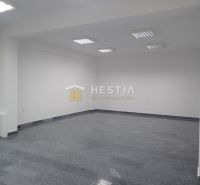 An empty commercial space with wood-patterned flooring and white walls.