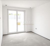 The interior of a family house with white walls and large balcony doors.