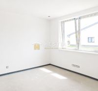 Bright room in a family house with large windows and white walls.
