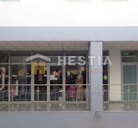 A glass facade of a shop with a display and clothing in a shopping center in Senica.