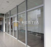 A glazed corridor with white frames leading to multiple spaces.