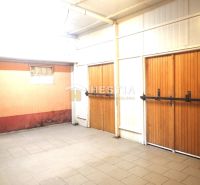 A garage in a family house with large wooden gates and ceramic tiles.