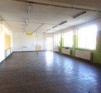 A spacious room in a family house with tiled flooring and large windows.