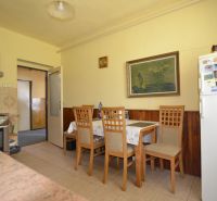 Dining room with wooden chairs and a table in a family house.