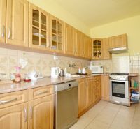 A kitchen in a family house with wooden cabinets, an oven, and appliances.