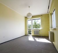 A room in a family house with light walls, a radiator, a large window, a hanging lamp.