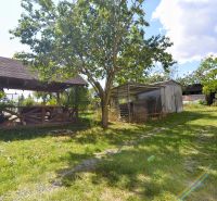 A garden at a family house in Badín with a gazebo and wooden shelters.