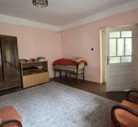 A room in a family house with furniture and pink walls.