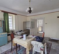 Living room in a family house with older furniture and carpets.
