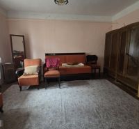 A living room in a family house with carpet flooring and wooden furniture.