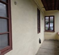 The veranda of a family house in Boldogkőújfalu with simple wooden window frames.