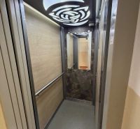 An elevator with modern lighting and wooden wall decor.