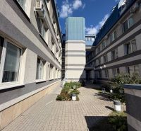 The building on Bajkalská Street in Bratislava-Ružinov with a landscaped courtyard and clear sky.