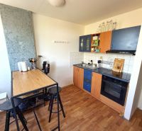 A kitchen in a 2-room apartment with a counter and a wooden decor floor.