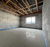 Newly constructed commercial spaces with a concrete floor and a large window in Lipany.