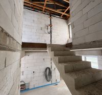 Interior with concrete stairs and raw walls in commercial premises.