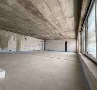 Commercial spaces with concrete walls, large windows, and white bricks on the floor.