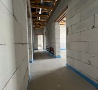 A part of commercial premises with concrete walls and an unfinished roof.