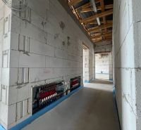 Interior of commercial spaces with a plain concrete floor and wiring on the wall.