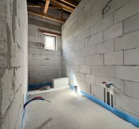 Interior construction of commercial spaces with installation wiring and a window on a white wall.