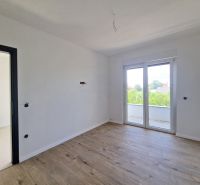 A room in a 3-room apartment with a wooden decor floor and large windows.