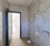 A bathroom with marble walls and a wooden decor floor in a 3-room apartment.