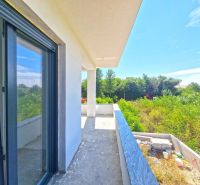 A balcony of a 3-room apartment in Privlaka with a view of greenery and blue sky.
