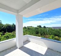 The balcony of a 3-room apartment in Privlaka with a view of greenery and a blue sky.