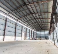 Warehouses and halls in Dulov with metal roofs and stored materials inside.