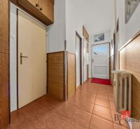 A hallway in a 3-room apartment with ceramic tiles, wooden paneling, and built-in cabinets.